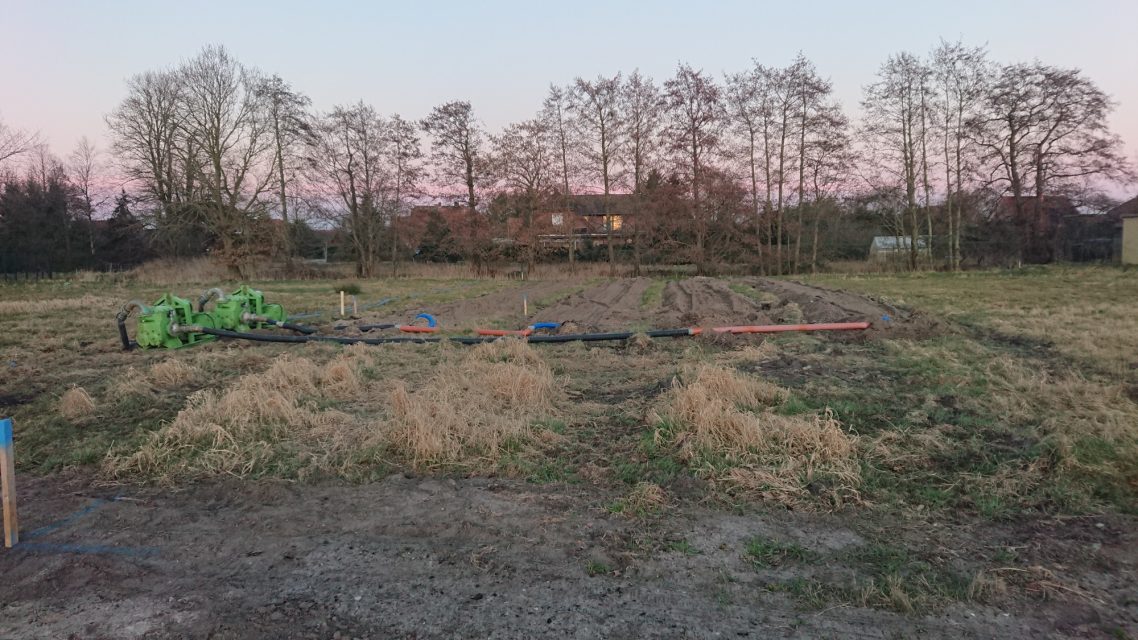 Der Boden wird vorbereitet Leere Grundstück mit einigen Werkzeugen und Bäumen im Hintergrund bei Sonnenuntergang.