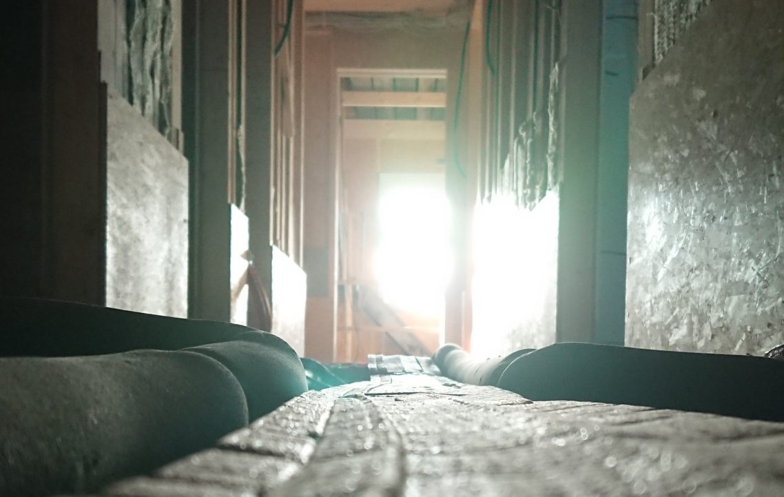 Jetzt geht es an den Innenausbau Blick auf einen schmalen Gang mit Licht, der durch eine Tür strahlt.