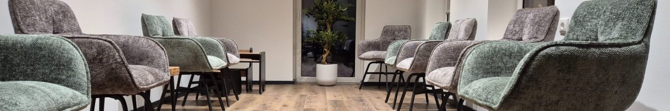 Moderne Wohnzimmermöbel mit einem grünen Sessel und einem grauen Sofa.